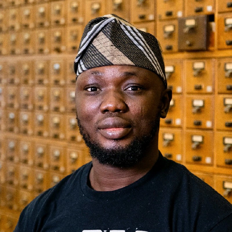 Portrait of Rasheed Adigun in a library card catalogue room